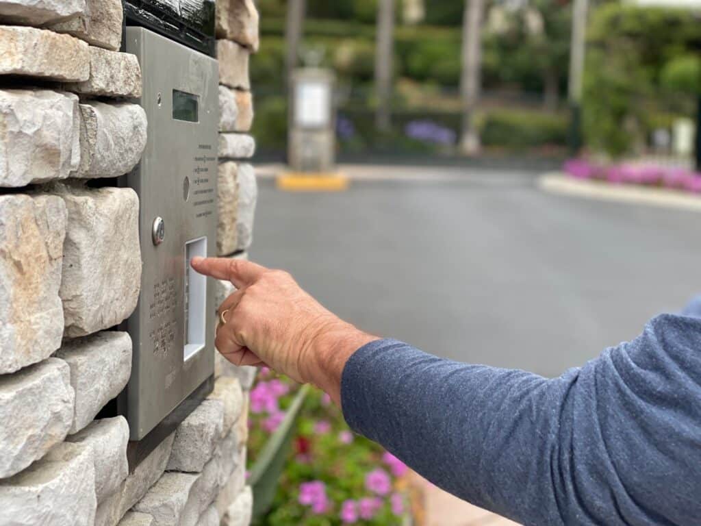 person pressing a security button in a gated community